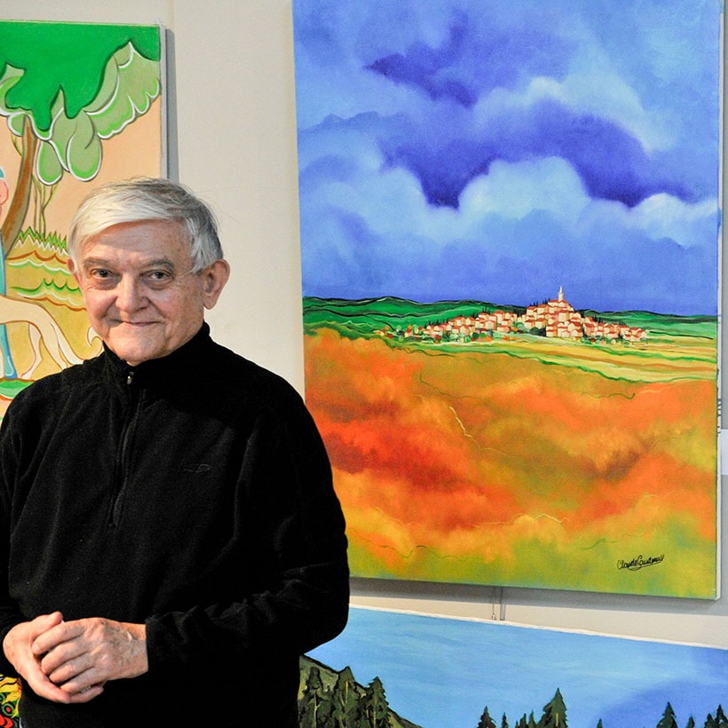 French Fest artist beside colorful paintings