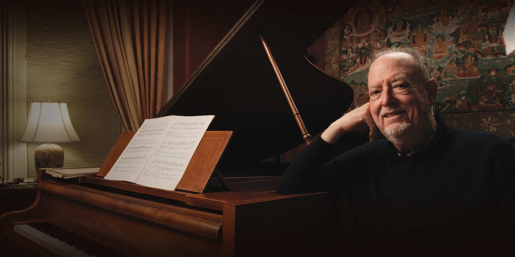Pianist Garrick Ohlsson seated beside a grand piano