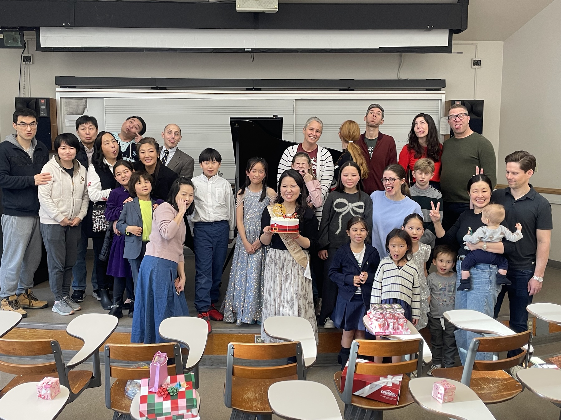 Students, families, and teachers sharing a playful group portrait