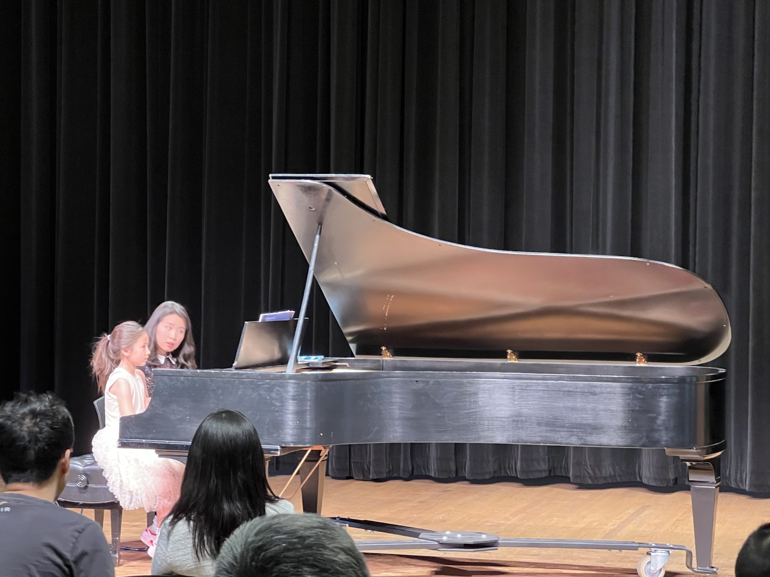 Chiao-Yu Wu guiding a student at the grand piano