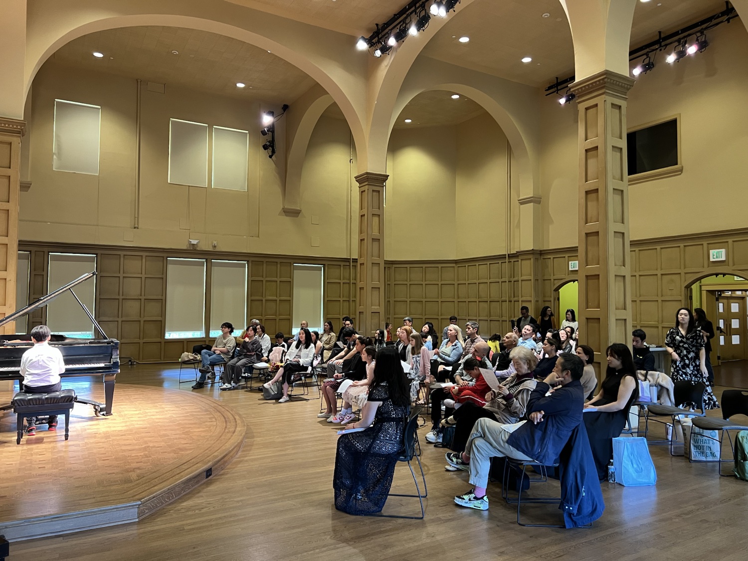 The recital audience listening to a student pianist