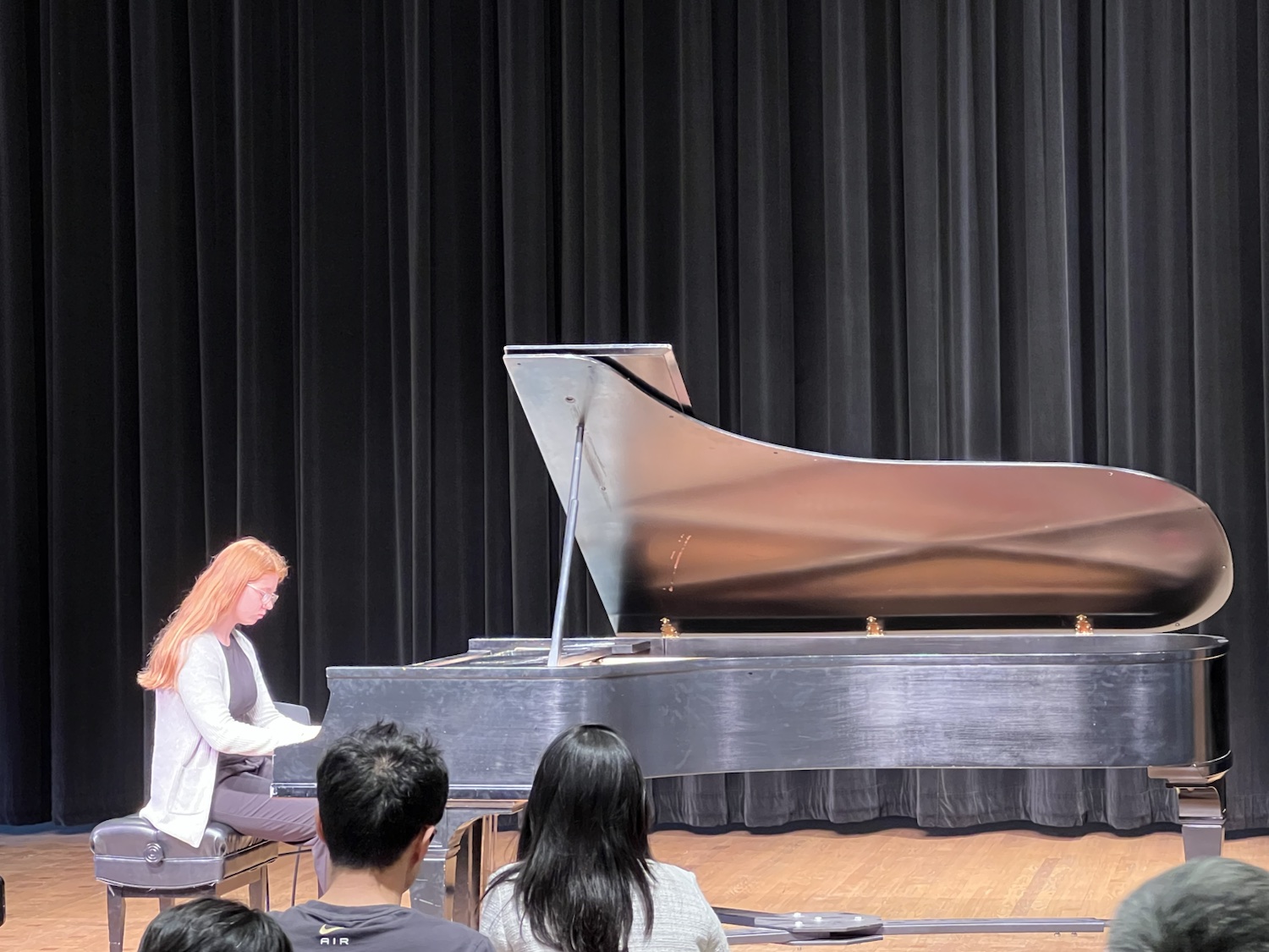 A student pianist performing on the recital stage
