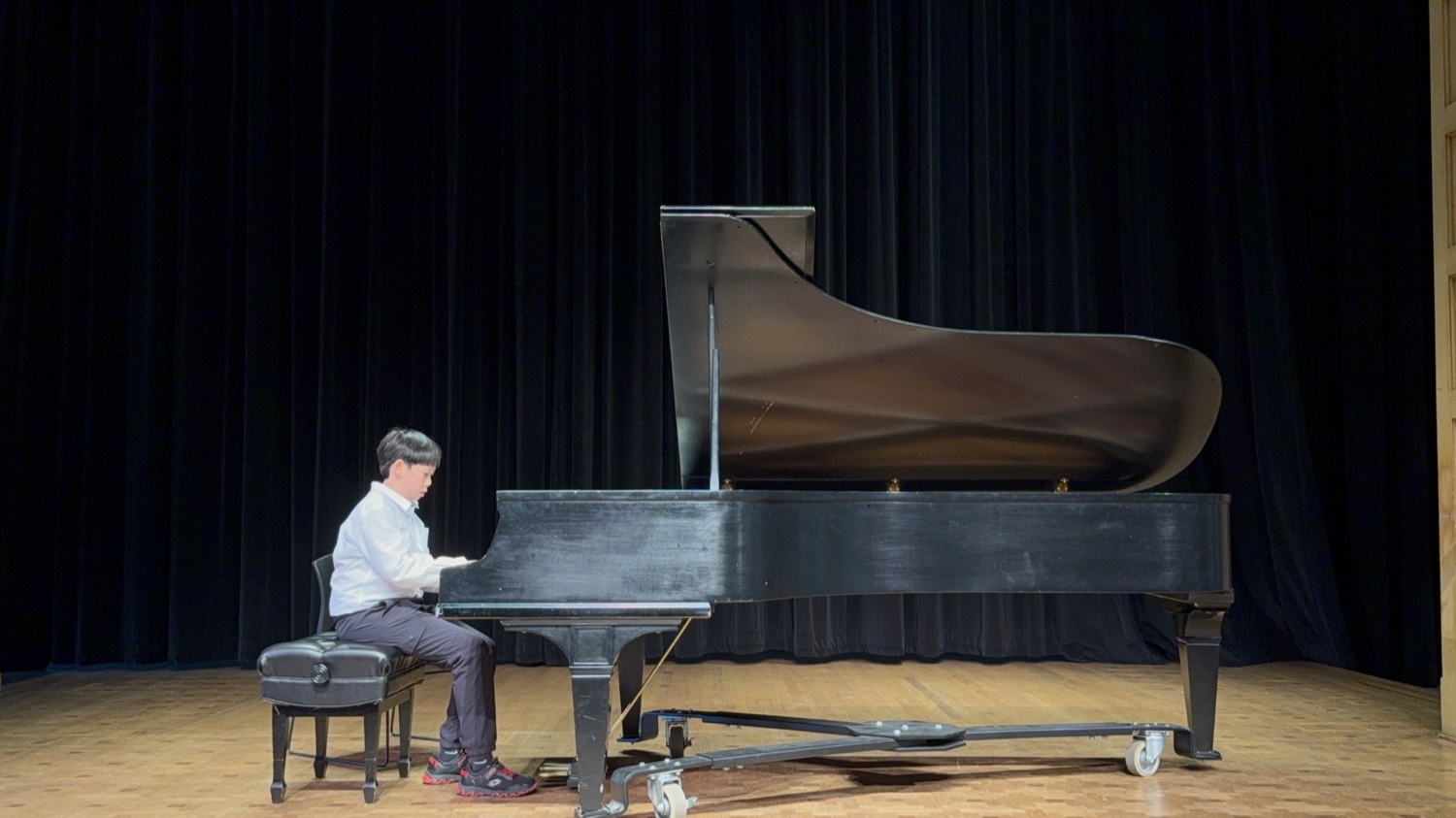 A student pianist performing before the audience