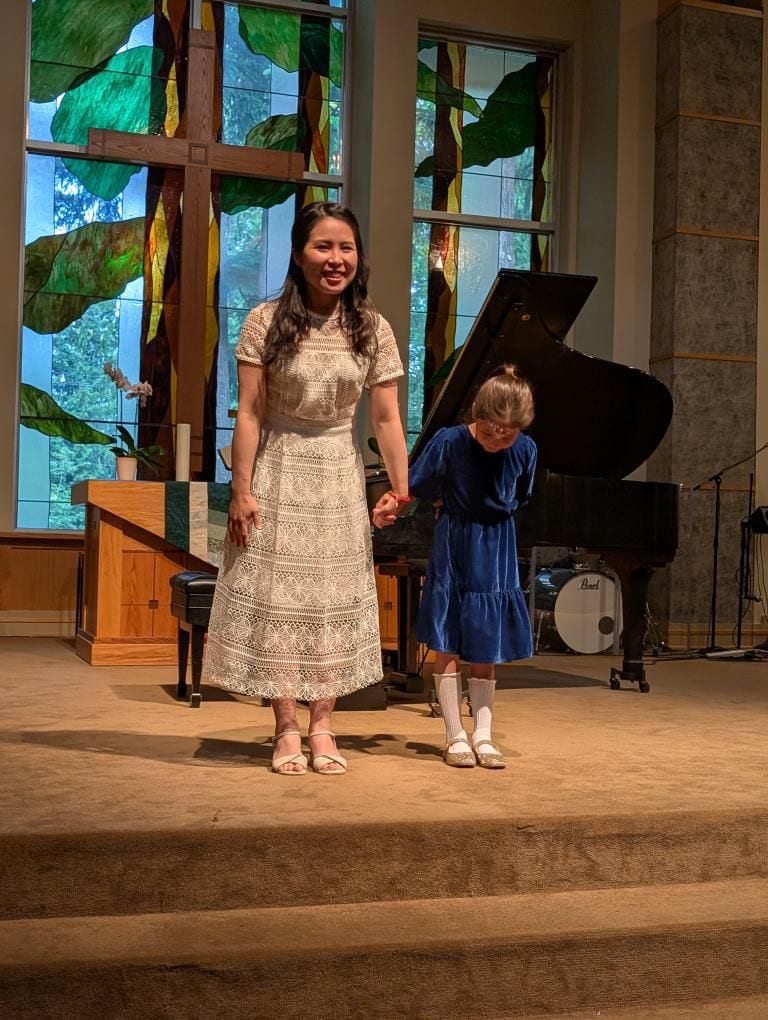 Chiao-Yu Wu and a young student taking a bow after performing