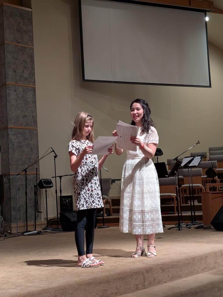 A student receiving a recital certificate on stage